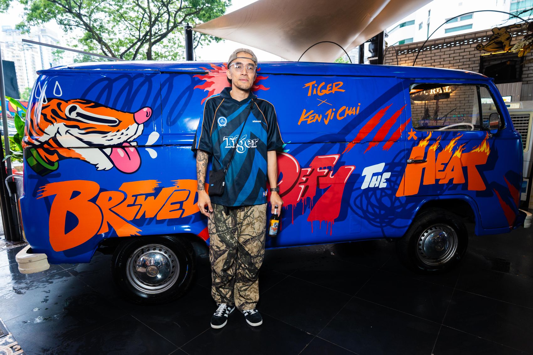 Kenji Chai with his latest artwork for Tiger Beer, featuring his bold, character-driven street art on the Kombi van